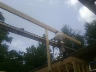 Carpenter setting a ridge beam over a new addition frame — Ice Dam Removal by Roofing Brothers in Los Alamitos