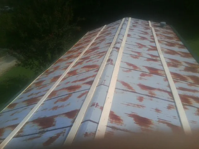 Rusted metal roof panels with new wood purlins before replacement — Storm Damage Roof Repair in Los Alamitos by Roofing Brothers