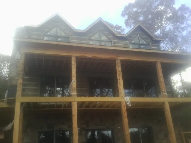 Dormers and porch framing on a large log home under construction — Roof Coating work by our crew in Los Alamitos
